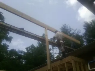 Carpenter setting a ridge beam over a new addition frame — Ice Dam Removal by Roofing Brothers in Gilcrest