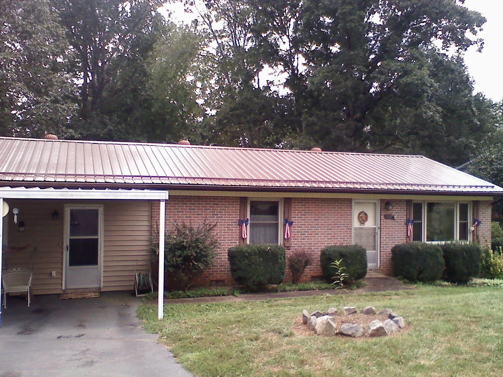 Bronze metal roof and carport on a brick ranch home — Roof Repair work by our crew in Gilcrest
